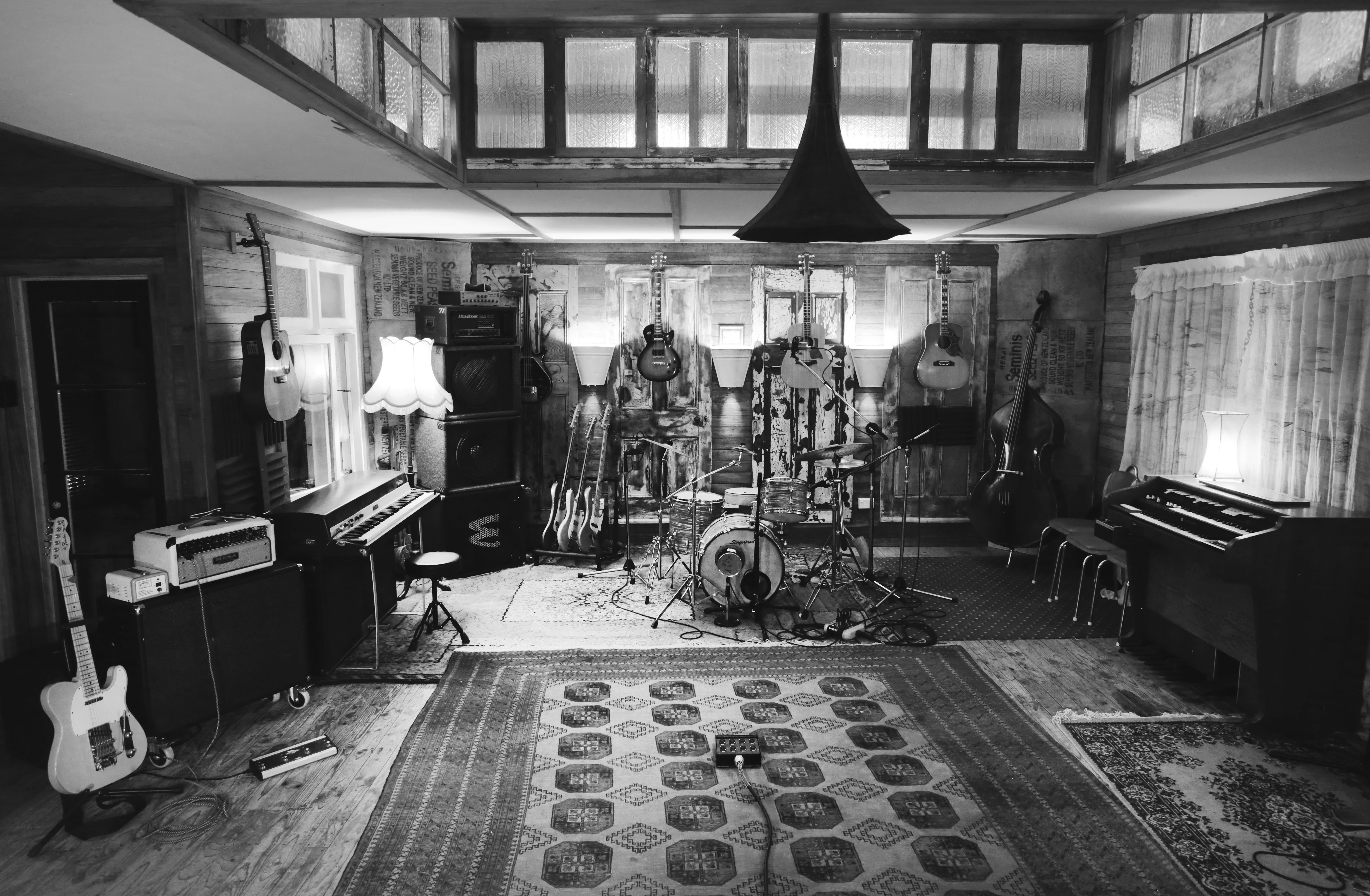Band room with assortment of electric, acoustic, and bass guitars; drumkit; and keyboards